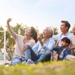 three generation asian family taking selfie outdoors
